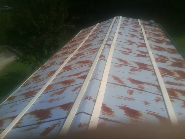 Rusted metal roof panels with new wood purlins before replacement — Storm Damage Roof Repair in Sherrill by Roofing Brothers